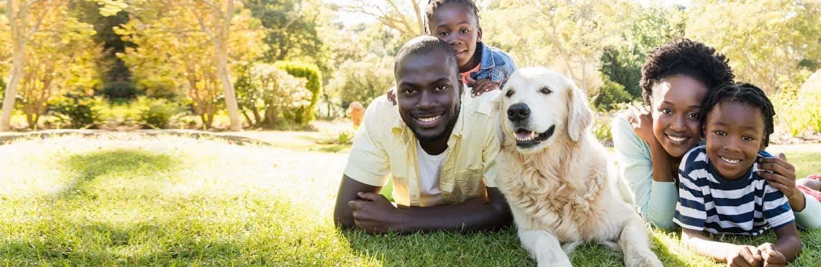 Family playing with dog in their yard